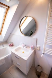 a white bathroom with a sink and a mirror at Apartamenty Centrum - Moonlight in Opole