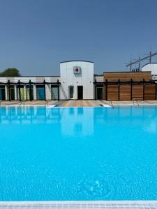 a large pool of blue water in front of a building at Serenity Luxury Hot Tub Breaks in Tattershall