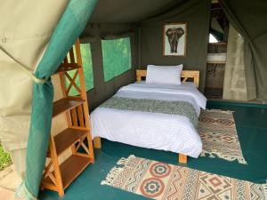 a bedroom with two beds in a tent at Amboseli Discovery Camp in Amboseli