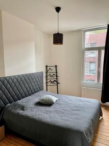 een slaapkamer met een bed met een kussen erop bij Boho Apartments - 2 Bedrooms in Antwerpen