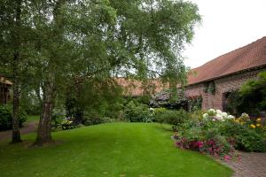 a green yard with a tree and some flowers at La Gran'Porte in Troisvaux