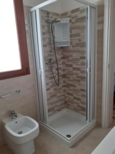 een badkamer met een douche en een toilet bij casa rosa in Tiggiano