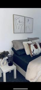 1 dormitorio con cama, mesa y dibujos en la pared en Roulsten Retreat en Clooney Park