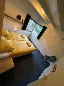 Habitación pequeña con cama y ventana en Bosrijke vakantiewoning en Lochem
