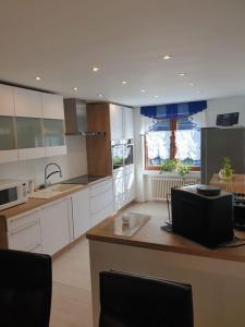 a large kitchen with white cabinets and a counter top at Oase der Ruhe: Haus mit Garten in Lohmar