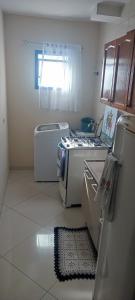 a kitchen with a stove and a refrigerator at Quarto na região central com alexa integrada e sacada in Curitiba