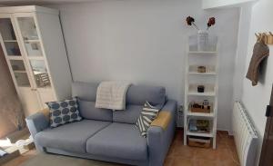 a living room with a blue couch and a shelf at El HOGAR DE LAS MARIPOSAS - VUTE-22-057 in Valdelinares