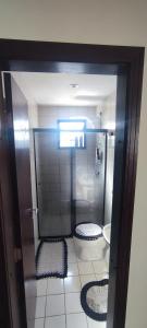 a bathroom with a toilet and a stall with two seats at Quarto na região central com alexa integrada e sacada in Curitiba
