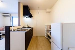 uma cozinha com pia e geladeira em Joe Stage Nishinakajima, 1 station from Shin-Osaka em Osaka
