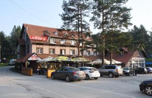 um edifício com carros estacionados ao lado de uma rua em Hotel Pepa em Divčibare