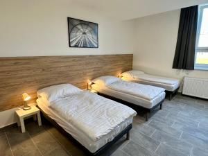 two beds in a room with two lamps on at Hotel Hangar in Mošnov