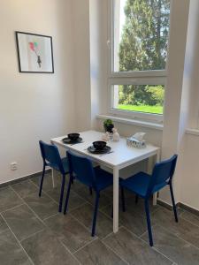 a white table and chairs in a room with a window at Hotel Hangar in Mošnov