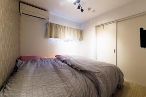 um quarto com uma cama e uma janela em Joe Stage Nishinakajima, 1 station from Shin-Osaka em Osaka mais 37 fotografias