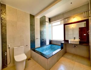 a bathroom with a tub with a toilet and a sink at Casa Eternal Resort Mandrem in Mandrem