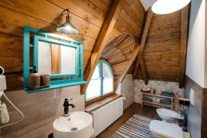 a bathroom with a wooden ceiling with a sink and a mirror at La bujda lu mosu in Borşa +31 photos
