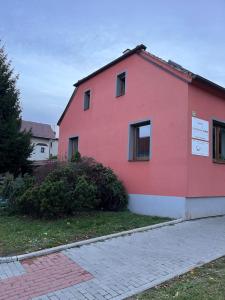 een rood gebouw met ramen aan de zijkant bij Apartmán Simmy in Modřice