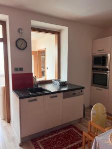 una cucina con lavandino e orologio sul muro di Apartmán Simmy a Modřice