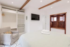 a white bedroom with a bed and a chair at Casa Canaria Azucena in Los Llanos de Aridane