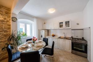 a kitchen with a table and chairs in a kitchen at Stone House Kaštela in Kaštela +50 photos