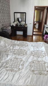 een slaapkamer met een wit bed, een dressoir en een spiegel bij AYXAN HOSTEL in Ganja