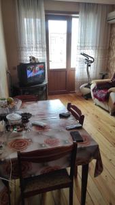 een woonkamer met een tafel en een televisie bij AYXAN HOSTEL in Ganja