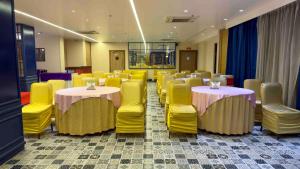Pokój z dwoma stołami i żółtymi krzesłami w obiekcie WoodApple Residency w Nowym Delhi