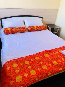 a bed with two pillows on top of it at Dungan House in Karakol