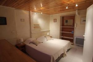 Peymeinade的住宿－Gîte Lou Caillou，卧室设有白色的床和木制天花板。