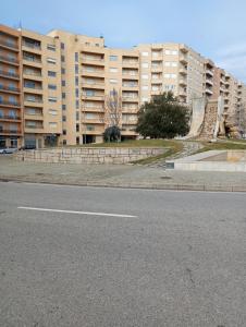 una calle vacía frente a edificios de apartamentos altos en Family holiday home new beds, en Bragança
