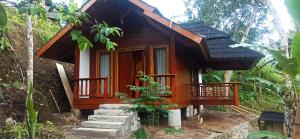 a small wooden house in the middle of a forest at Nea Cottage Lombok in Tetebatu