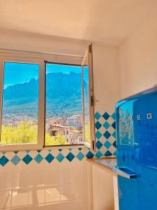 - Baño con 2 ventanas con vistas en Monolocale con vista sulle montagne en Oliena