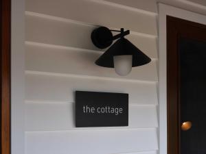 una lampada nera e un cartello che legge il caffè di Shawwood Cottage a Mudgee