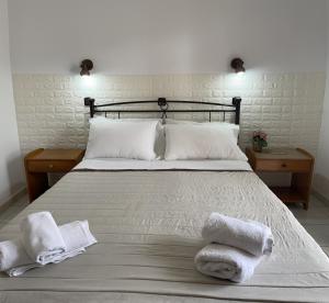 a bedroom with a bed with towels on it at Oscar Hotel Lefkada in Nydri