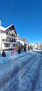 una calle cubierta de nieve frente a un edificio en La Cascade 2, en Moieciu de Sus