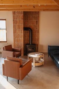 a living room with a fireplace and a couch and a table at Chaty Jagi in Czorsztyn