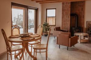 a dining room with a table and chairs and a fireplace at Chaty Jagi in Czorsztyn +29 photos