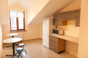 a small kitchen with a table and a refrigerator at Minihotel Freedom in Lviv