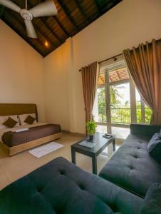 a bedroom with a couch and a bed and a window at HIDEOUT BY CMB APARTMENTS in Mount Lavinia