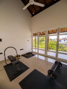een kamer met een fitnessruimte met fitnessapparatuur en ramen bij HIDEOUT BY CMB APARTMENTS in Mount Lavinia