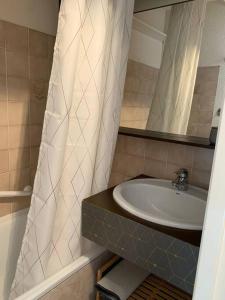 a bathroom with a sink and a shower curtain at 4 personnes in Chamrousse