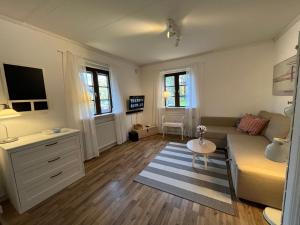 a living room with a couch and a table at Davidslids cottage in Löddeköpinge