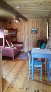 a room with a bed and a table and a bunk bed at Mogard in Skjåk