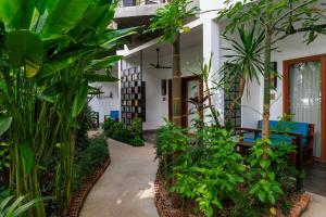 暹粒的住宿－SAKABAN Suite，种有植物和桌子的房子的庭院