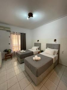 two beds in a room with two bedsvisor at Oscar Hotel Lefkada in Nydri