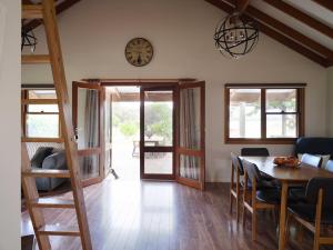 a dining room with a table and a clock on the wall at Shawwood Cottage in Mudgee