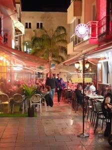 a group of people sitting at a restaurant at night at Superb Penthouse in Central Fuengirola in Fuengirola