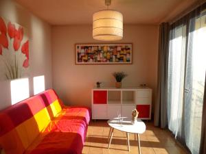 sala de estar con sofá colorido y mesa en Saint Palais sur Mer - APPARTEMENT FACE MER sur la corniche de NAUZAN, en Saint-Palais-sur-Mer