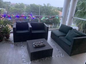 a patio with two couches and a table and christmas lights at Charming house in Curacao in Willemstad