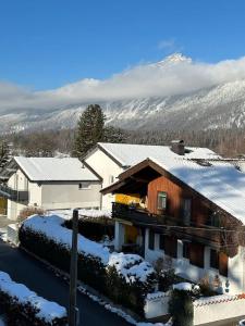 een huis bedekt met sneeuw met bergen op de achtergrond bij Haus Schmidhuber Wohnung 3 in Grossgmain