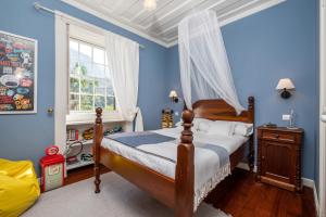 a bedroom with blue walls and a bed and a window at Casa Grande da Camélia in São Vicente